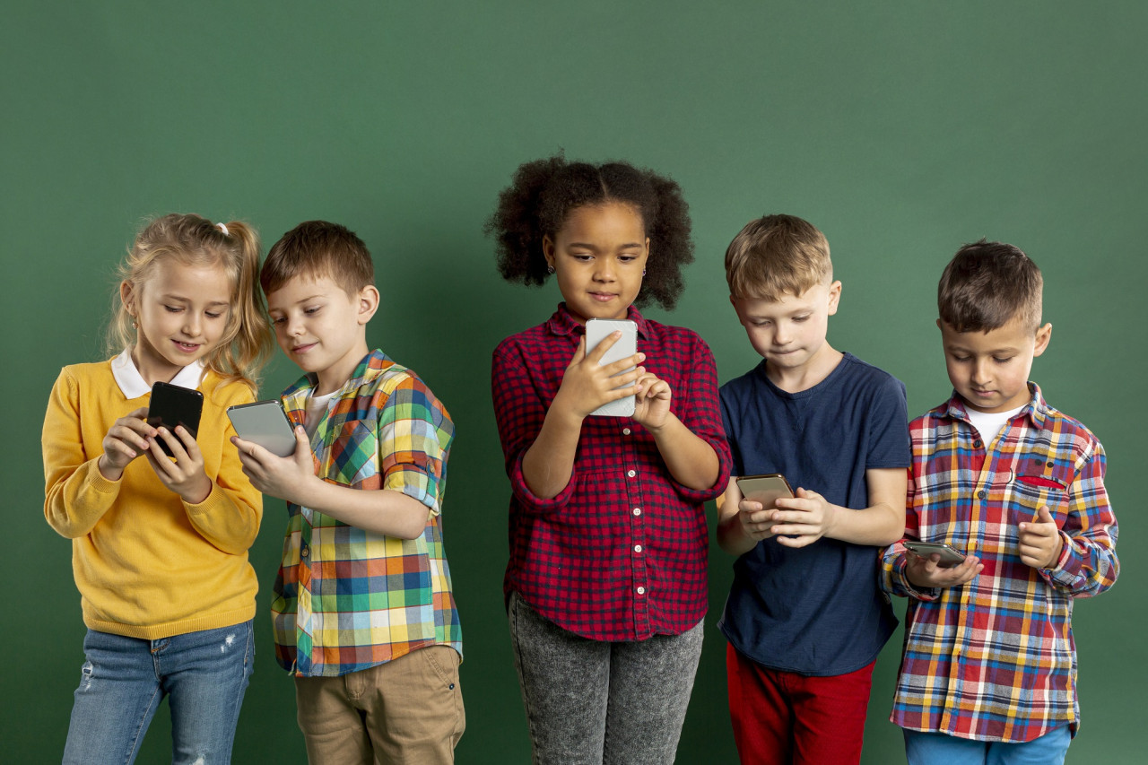 Niños usando el celular. Foto Freepik